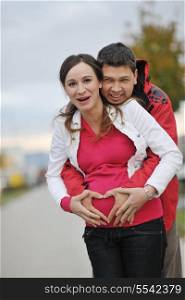 happy couple outdoor, beautiful pregnant woman with her husband