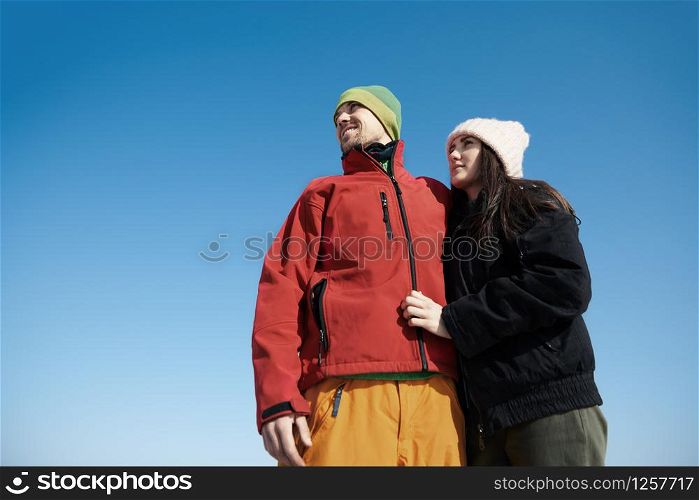 Happy couple outdoors against the clear blue sky