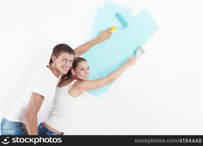 Happy couple paint the walls at home