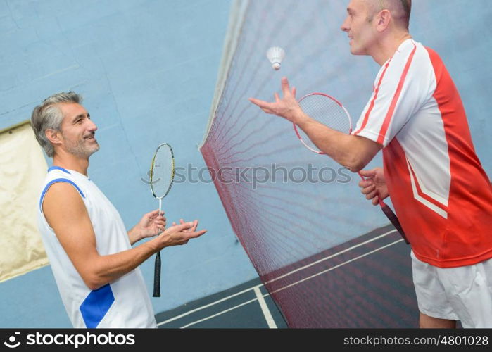 happy couple playing badminton togheter indoors