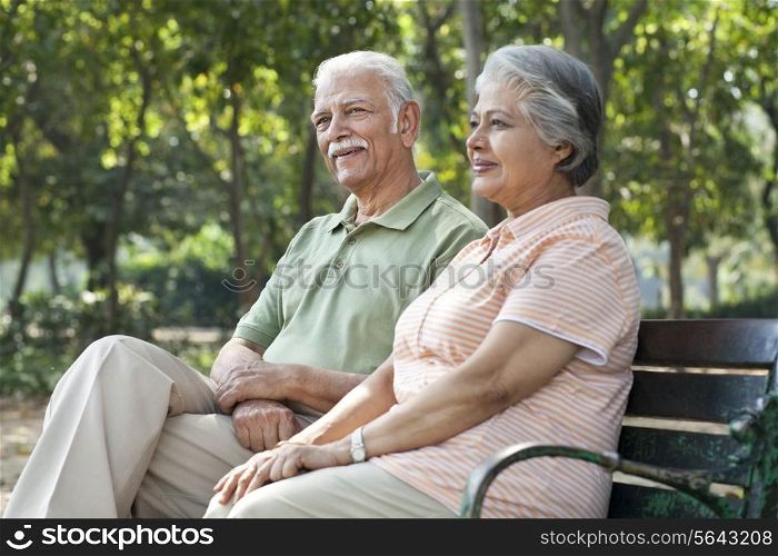Happy couple relaxing on park bench