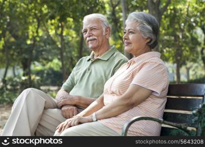 Happy couple relaxing on park bench