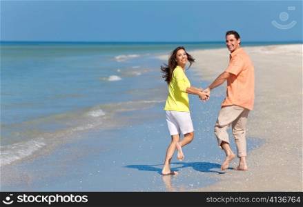 Happy Couple Running Holding Hands on A Beach