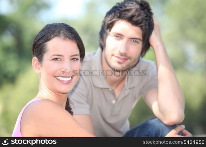 Happy couple sat in the park