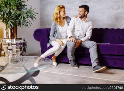 Happy couple sitting in a comfortable couch in the living room