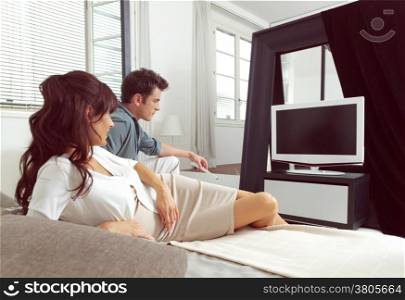 happy couple sitting on couch and watching television together