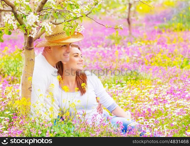 Happy couple spending time in beautiful blooming garden, wife and husband hugging outdoors, romantic date, love concept