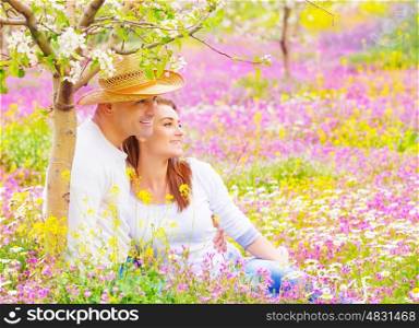 Happy couple spending time in beautiful blooming garden, wife and husband hugging outdoors, romantic date, love concept