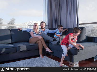 happy couple spending time with kids using tablet computer on sofa at home