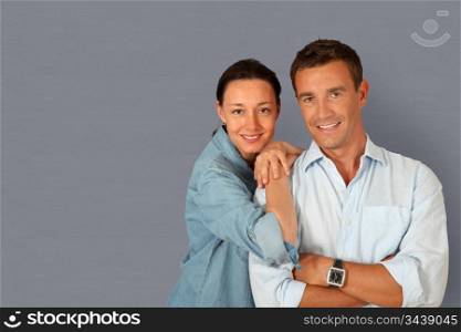 Happy couple standing on grey background