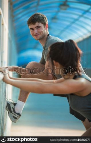 Happy couple stretching while standing in the city urban background