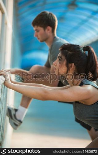 Happy couple stretching while standing in the city urban background