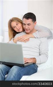 Happy couple surfing on internet at home