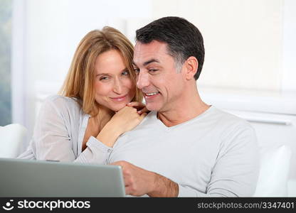 Happy couple surfing on internet at home