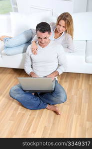 Happy couple surfing on internet at home