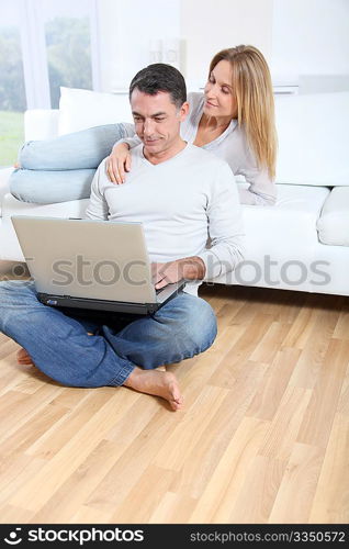 Happy couple surfing on internet at home