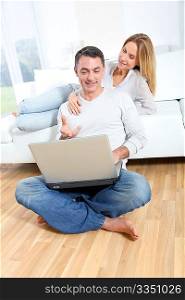 Happy couple surfing on internet at home