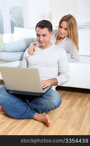 Happy couple surfing on internet at home