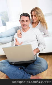 Happy couple surfing on internet at home