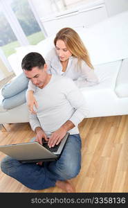 Happy couple surfing on internet at home