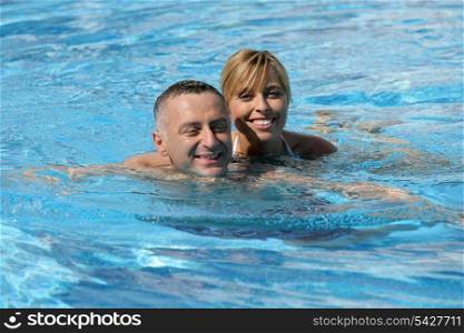 Happy couple swimming together in pool