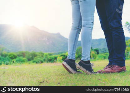 Happy couple take a romantic walk in green grass field on the hills. Travel and honeymoon concept.