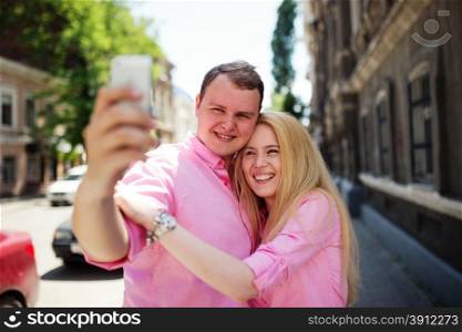 Happy couple taking photo of themselves or making selfie by smartphone