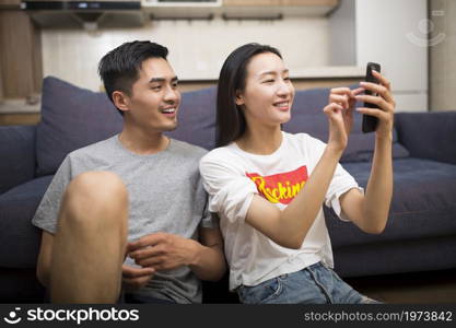 Happy couple taking selfies in the living room