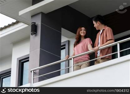 happy couple talking on balcony at home
