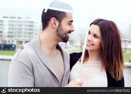 Happy couple under a white umbrella in the city