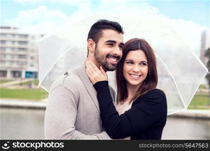 Happy couple under a white umbrella in the city