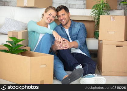 happy couple unpacking boxes and moving into a new home