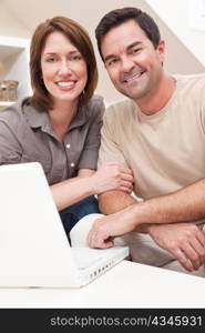 Happy Couple Using Laptop Computer at Home