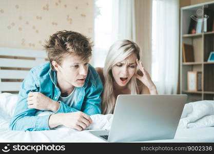 Happy couple Using laptop computer on the bed