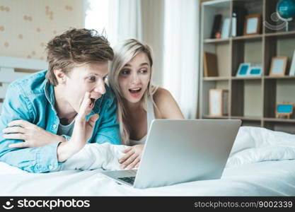 Happy couple Using laptop computer on the bed