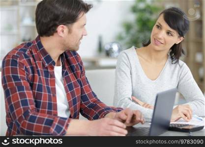 happy couple using laptop in living room