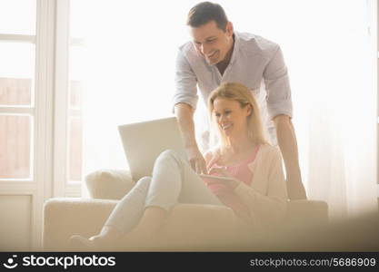 Happy couple using laptop together at home