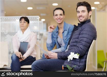 happy couple waiting at family planning clinic