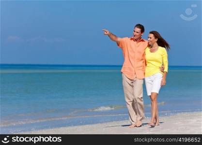 Happy Couple Walking and Pointing on A Beach