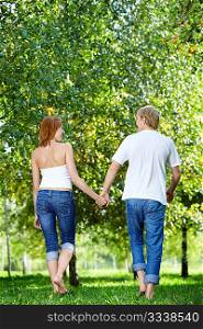 Happy couple walking in a summer garden