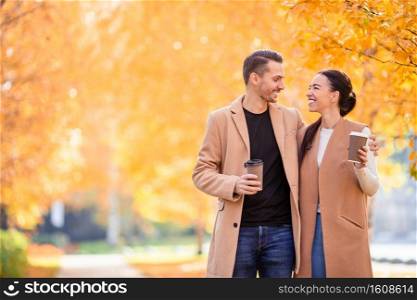 Happy couple walking in autumn park on a sunny fall day. Happy family walking in autumn park on sunny fall day