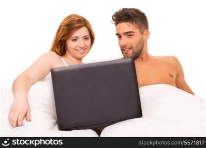 Happy couple watching a movie in bed