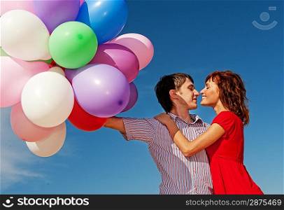 Happy couple with colorful balloons outdoors
