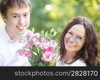 Happy couple with flowers in spring park