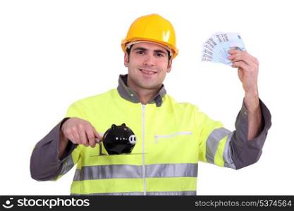 happy craftsman holding money in cash and a pig bank