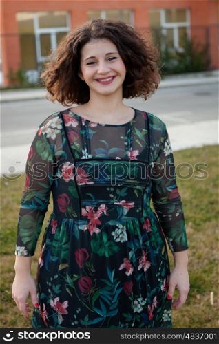 Happy curvy girl with curly hair in the street with a flowered dress