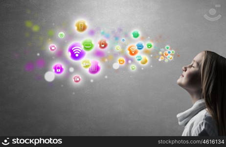 Happy cute little girl looking up at colorful icons of different entertainment apps. Profile of cute girl