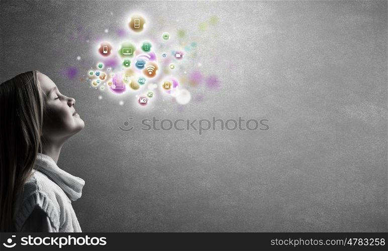 Happy cute little girl looking up at colorful icons of different entertainment apps. Profile of cute girl