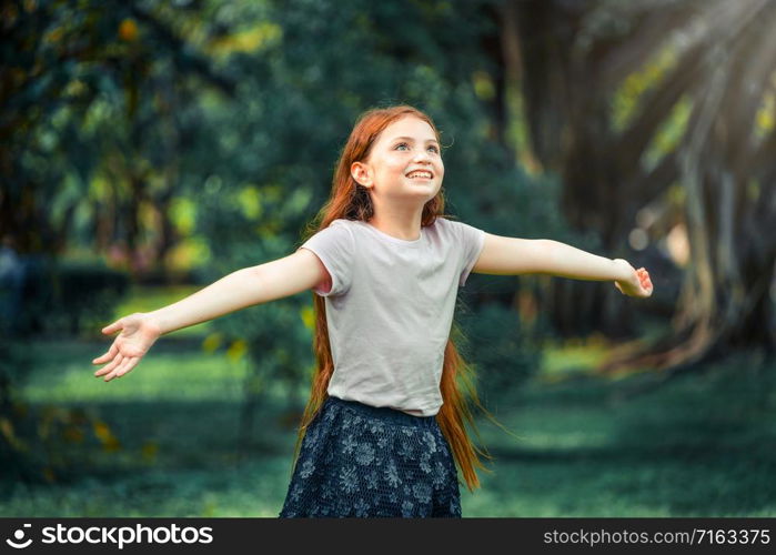 Happy cute little girl playing in the outdoor park in summer. Child expression and lifestyle.