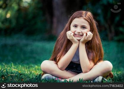 Happy cute little girl playing in the outdoor park in summer. Child expression and lifestyle.